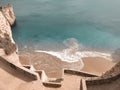 A sharp stairs lead to the the warm cerulean sea and the mild sand among the ridiculously shaped rocks