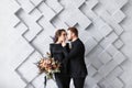 Tender wedding couple posing on gray geometric background in studio