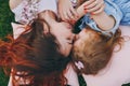 Tender woman and little cute child baby girl lie on pillows on grass in park hug, embrace and rest, have fun. Mother Royalty Free Stock Photo