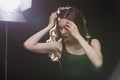 Tender woman standing near studio spotlight and looking down Royalty Free Stock Photo