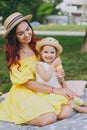 Tender woman play and sit on green grass in park, rest and hug hold soap bubble blower with little cute child baby girl Royalty Free Stock Photo