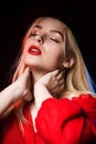 Tender young woman in hat wearing red blouse with naked shoulder Royalty Free Stock Photo