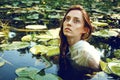 Tender young woman swimming in the pond among water lilies Royalty Free Stock Photo