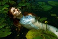 Tender young woman swimming in the pond among water lilies Royalty Free Stock Photo