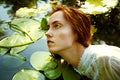 Tender young woman swimming in the pond among water lilies Royalty Free Stock Photo