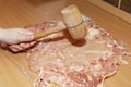 Tenderizing the meat with mallet on the kitchen board Royalty Free Stock Photo