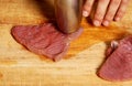 Tenderizing red meat on the kitchen board Royalty Free Stock Photo