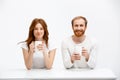 Tenderless redhead girl and boy drinking coffee sitting at w Royalty Free Stock Photo