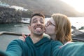 Tenderness Friends kissing in the check and hugging in the coast pool. Caucasian wife with glasses giving kiss to handsome latin Royalty Free Stock Photo