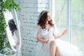 Tenderness and sensuality concept. Beautiful brunette model posing on bed in white lingerie. Sensual portrait of young Royalty Free Stock Photo