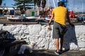 Tenerife, Spain - December 15, 2019: A man with his dog standing at a wall in Puerto de la Cruz. Royalty Free Stock Photo