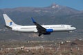 Jettime Airlines flies in the blue sky. Landing at Tenerife Airport. El Teide volcano in the background