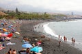 TENERIFE, SPAIN - JUNE 2, 2019: Purto de la Cruz cityscape with Playa Jardin black beach with bathers, Tenerife Royalty Free Stock Photo