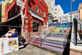 Colourful commercial empty street with restaurants shopping stores, ornate painted stair and