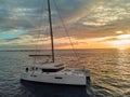 Lonely modern yacht in calm waters of open Atlantic Ocean at sunset