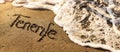 Tenerife vacations - text and ocean wave on beach sand. copy space