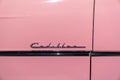 Cadillac logo typography on the door of a pink Cadillac convertible