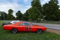 Replicas of the General Lee Charger and the Sheriff car, from the television series The Dukes of Hazzard, parked along a country r