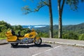 Yellow Honda motorcycle parked in a parking lot in the mountains