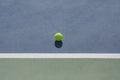 Tennis ball on blue and green hard court Royalty Free Stock Photo