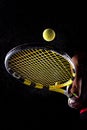 Tennis ball bouncing on racket. Dirt or magnesium dust dots visible in the air. Female player holding racket Royalty Free Stock Photo