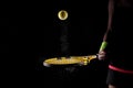 Tennis ball bouncing on racket. Dirt or magnesium dust dots visible in the air. Female player holding racket Royalty Free Stock Photo