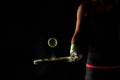 Tennis ball bouncing on racket. Dirt or magnesium dust dots visible in the air. Female player holding racket Royalty Free Stock Photo