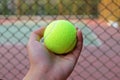 Tennis ball on hand blur background court