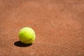 Tennis ball lying on orange sand