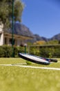 Tennis ball and tennis racket lying on sunny outdoor grass tennis court, with copy space Royalty Free Stock Photo