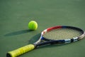 Tennis ball and racket under late evening sunlight Royalty Free Stock Photo