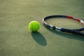 Tennis ball and racket under late evening sunlight Royalty Free Stock Photo