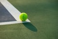Tennis ball and racket under late evening sunlight Royalty Free Stock Photo