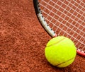 Tennis ball and racquet on a tennis clay court Royalty Free Stock Photo