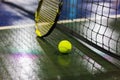 Tennis ball, racquet and net on wet ground after raining Royalty Free Stock Photo
