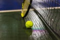 Tennis ball, racquet and net on wet ground after raining Royalty Free Stock Photo