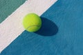 Tennis ball on white line on hard tennis court of blue color. Flat lay, top view, copy space. Summer sport concept. Tennis court Royalty Free Stock Photo