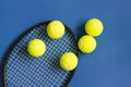 Tennis balls and black racket on blue background. Color of the year 2020, horizontal format photo. Active lifestyle concept