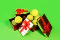 Tennis balls in holiday gift red boxes as present for Christmas, New Year, birthday on green color background. Royalty Free Stock Photo