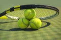 Tennis balls and racket on the grass court. Royalty Free Stock Photo