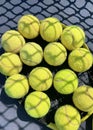 Tennis balls on the racket on hard court by the net. Tennis net shadows on tennis yellow balls. Royalty Free Stock Photo