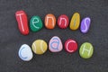 Tennis coach text with colored stones over black volcanic sand