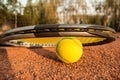 Tennis concept with racket and ball on clay at sunset Royalty Free Stock Photo