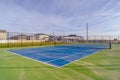 Tennis court against homes mountain and sky Royalty Free Stock Photo