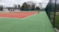 Tennis court empty red and green with sport net Royalty Free Stock Photo