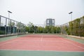 Tennis court near trees and a hotel