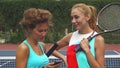 Tennis girls discussing while sharing a smartphone Royalty Free Stock Photo