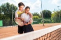 Tennis instructor teaches girl to hold the racket correctly.