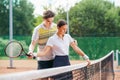 Tennis instructor teaches girl to hold the racket correctly.