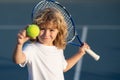 Tennis kid. Child with tennis racket and tennis ball playing on tennis court. Royalty Free Stock Photo